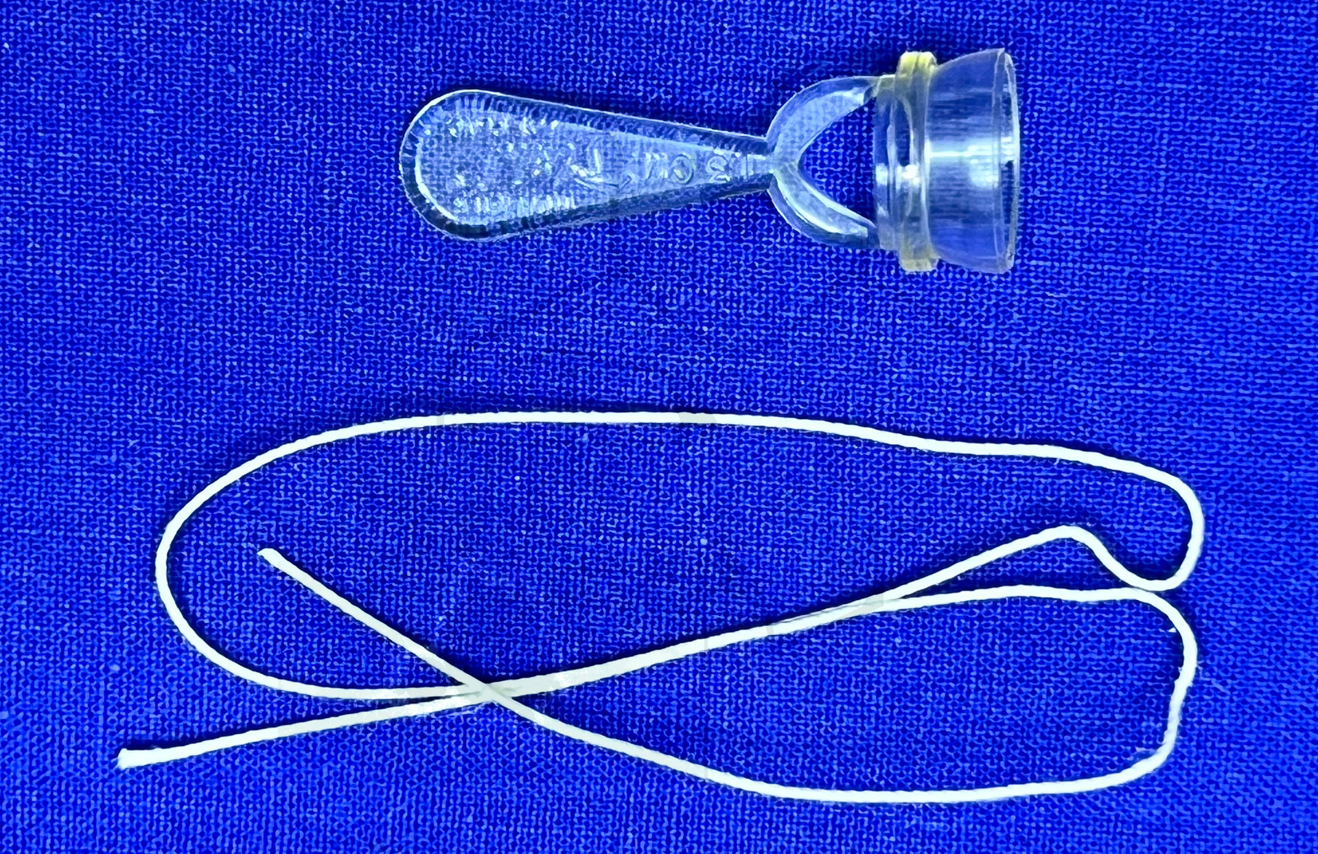 Plastibell, Vorderansicht mit der Schnur, mit der die Vorhaut abgebunden wird